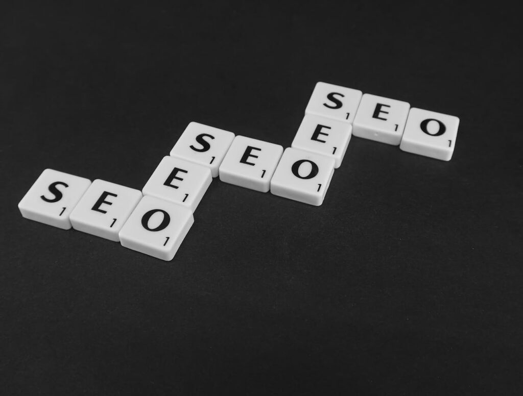 pexels photo 7119258 SEO spelled with Scrabble tiles on a black surface, representing search engine optimization concepts.